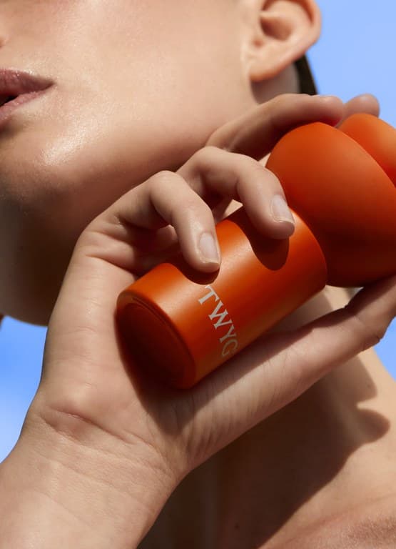 TWYG Skincare bottle held against sky